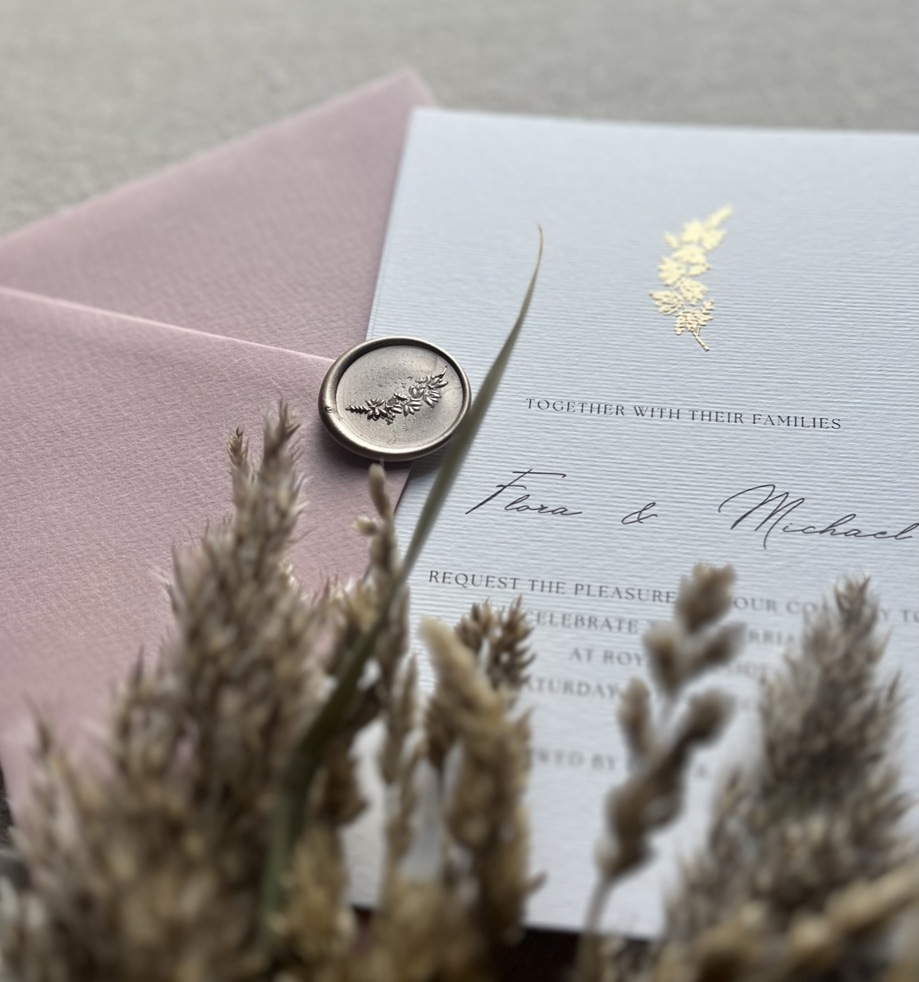 Pink and white hand-embossed invitation with seal